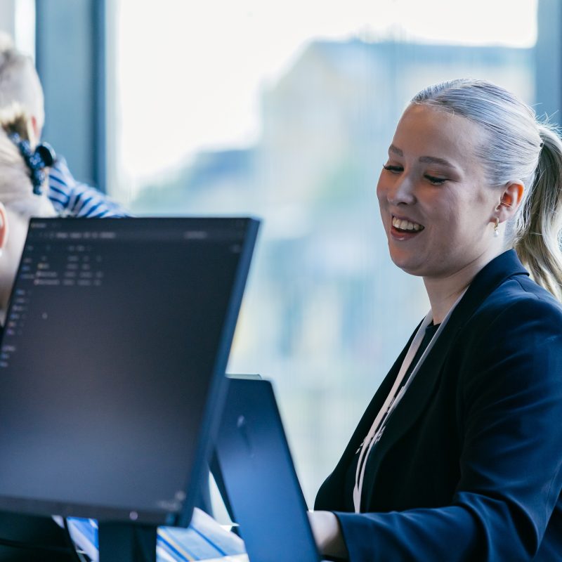 Hymyilevä nainen tietokoneen äärellä